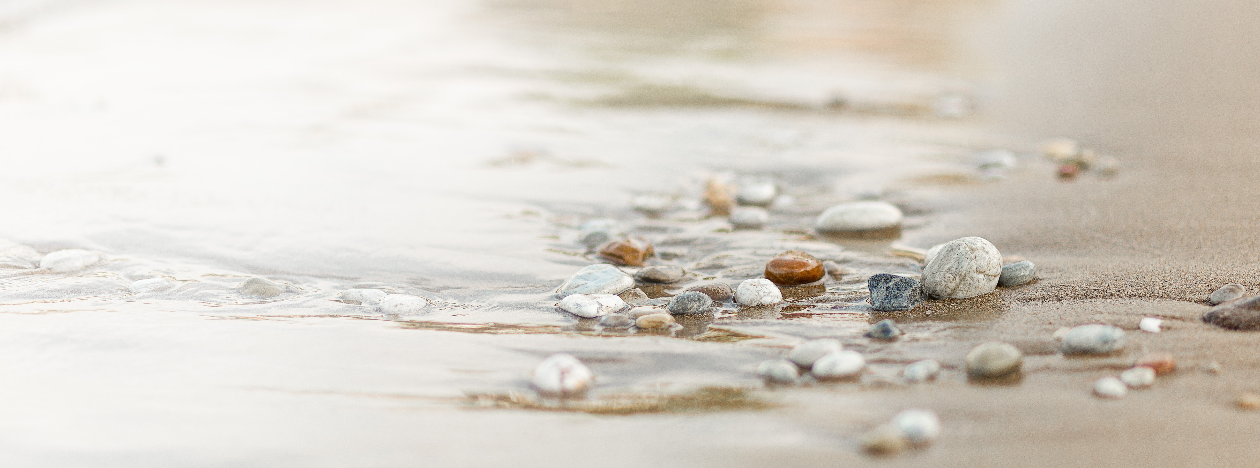 Kiesel am Ufer im flachen Wasser