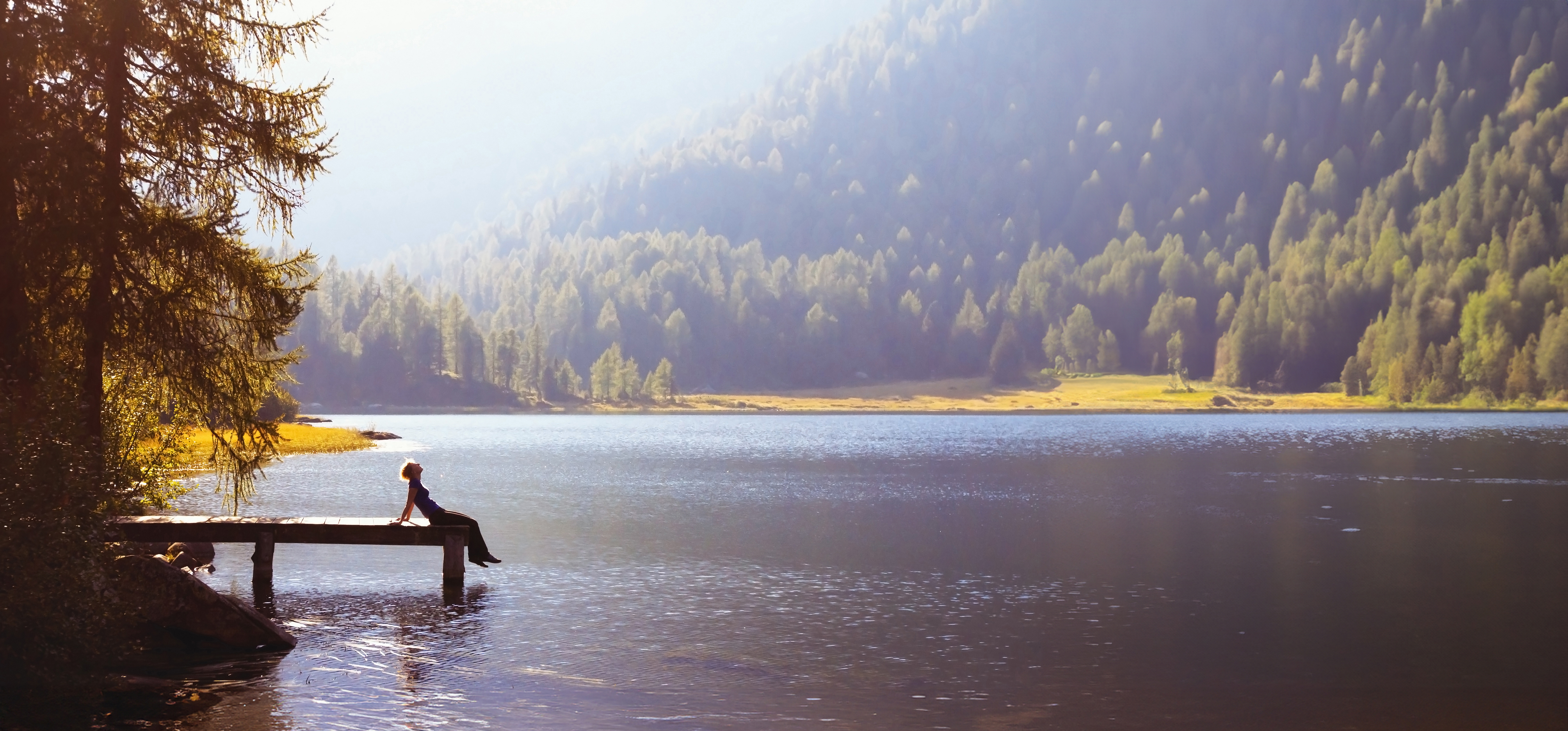 Frau auf einem Steg am Bergsee